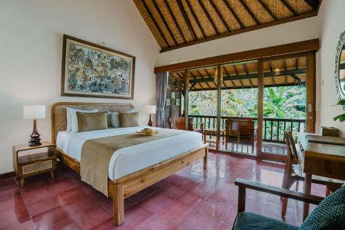 een slaapkamer met een groot bed en een balkon bij Jati Home Stay in Ubud