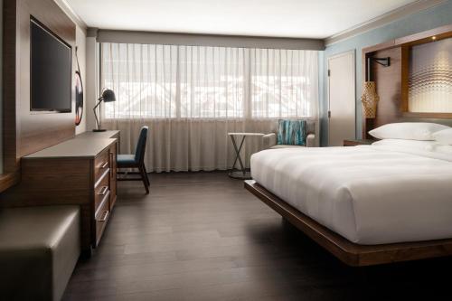 um quarto de hotel com uma cama e uma televisão em Seattle Airport Marriott em SeaTac