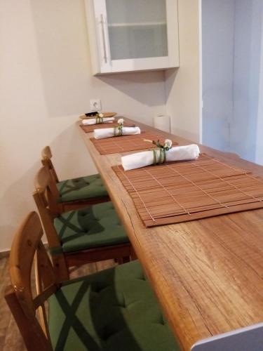 a long wooden table with white napkins on it at Flora's Traditional House in Malona Village