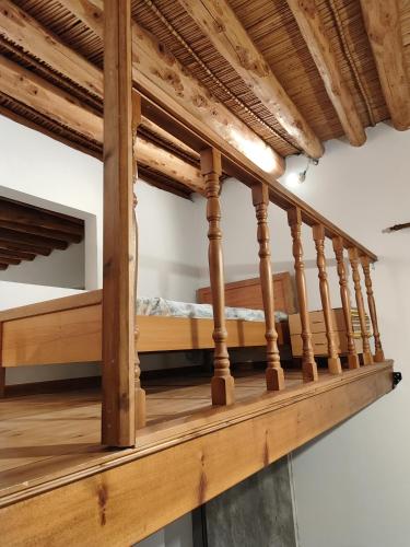 a wooden staircase with a bed on it at Flora's Traditional House in Malona Village