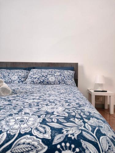 - une chambre avec un lit doté d'un couvre-lit bleu et blanc dans l'établissement Bilocale3 a pochi passi da Milano, à Sesto San Giovanni