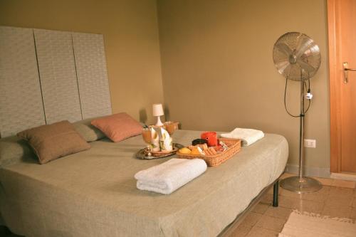 a bed with a basket of toys and a fan at B&B SEBA e PAOLA in Sonnino