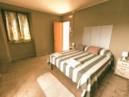 a bedroom with a bed with a striped blanket at B&B SEBA e PAOLA in Sonnino