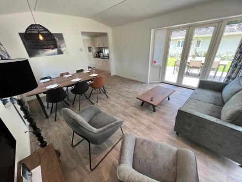 a living room with a couch and a table at Luxe Chalet Inn Otterlo op de Veluwe aan het Water! in Otterlo