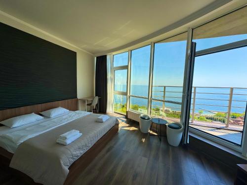 ein Hotelzimmer mit einem Bett und einem großen Fenster in der Unterkunft Odesa Pearl Arcadia in Odessa
