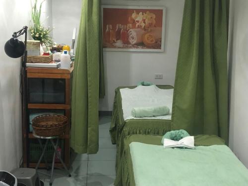 two beds in a room with green curtains at Badladz Beach and Dive Resort in Puerto Galera