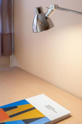 a desk with a lamp and a paper on it at La City Mercado in Alicante