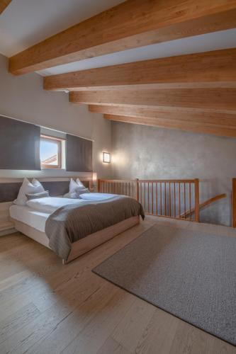 a bedroom with a large bed and wooden ceilings at Josef Mountain Resort in Avelengo