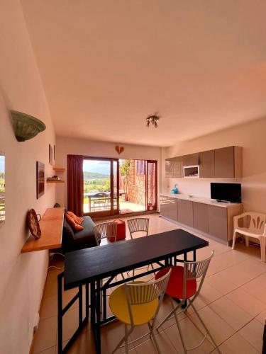 a kitchen and living room with a table and chairs at Residenze Coda Cavallo in San Teodoro