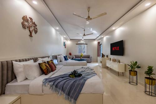 a large bedroom with two beds and a couch at ELIVAAS 6 BHK Farmhouse with Pvt Pool & Garden - Enchantia in Bhundsi