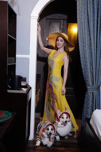 a woman in a yellow dress standing next to two dogs at The Quba Boutique Hotel Pattaya in Pattaya Central