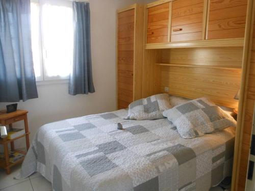 une chambre avec un lit avec une couverture à carreaux dans l'établissement APPT 3 PIECES 28m2 + LOGGIA 8m2 REF 4046, à Le Castellas