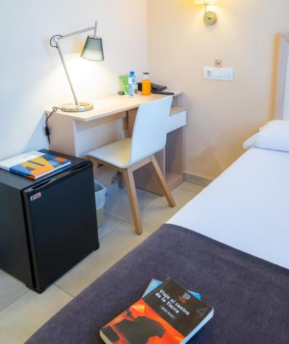 a bedroom with a desk and a bed with a lamp at La City Mercado in Alicante