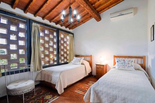 1 dormitorio con 2 camas y ventana en Villa Olivo, en Lastra a Signa