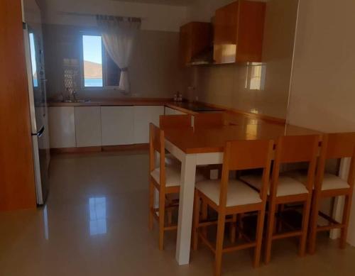 eine Küche mit einem Holztisch und Stühlen in der Unterkunft L2B - São Vicente in Mindelo