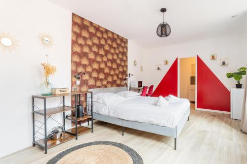 a bedroom with a white bed and a red wall at S&K Suite Grande rue Roubaix - Chambre spacieuse et SDB privée - Netflix et Cuisine in Roubaix