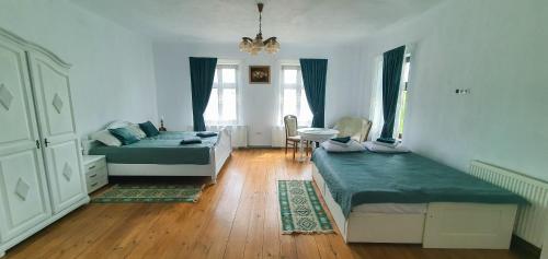 a bedroom with two beds and a table and chairs at Cazare La Cetate in Moşna