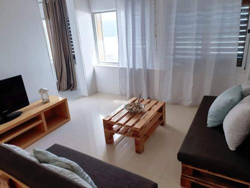 ein Wohnzimmer mit einem Sofa und einem Couchtisch in der Unterkunft L2B - São Vicente in Mindelo
