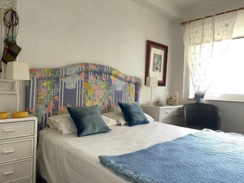 Schlafzimmer mit einem großen Bett mit Kopfteil in der Unterkunft Hortensias de jardín in O Grove