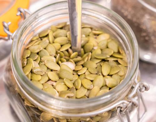 a glass jar filled with green pumpkin seeds at La City Mercado in Alicante