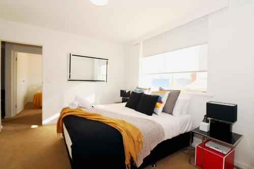 um quarto com uma cama grande e uma janela em The Ivy on Munro em Melbourne