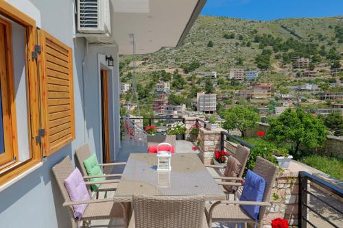 a table and chairs on a balcony with a view at Vila Nanaj in Sarandë