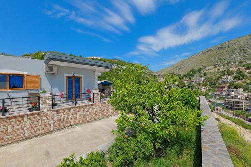 a white house with a hill in the background at Vila Nanaj in Sarandë