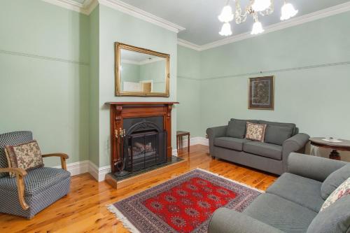 a living room with a couch and a fireplace at Hopkins River Homestead in Allansford