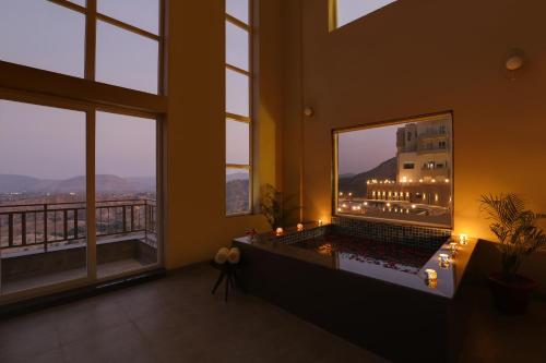 a room with a bath tub in a room with windows at Lemon Tree Resort, Kumbhalgarh in Kumbhalgarh