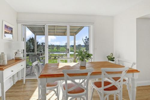 a kitchen and dining room with a wooden table and chairs at Mollison Park Farm in Emu Flat