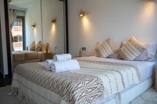 um quarto com uma cama com toalhas em L'appart by Louhou Collection em Marrakech