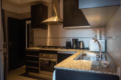 uma cozinha com um lavatório e um fogão em L'appart by Louhou Collection em Marraquexe