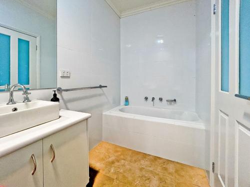 a white bathroom with a tub and a sink at Mollison Park Farm in Emu Flat