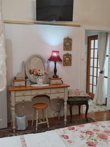 a room with a desk with a lamp and a mirror at A La Maison Boutique Guesthouse in Parys