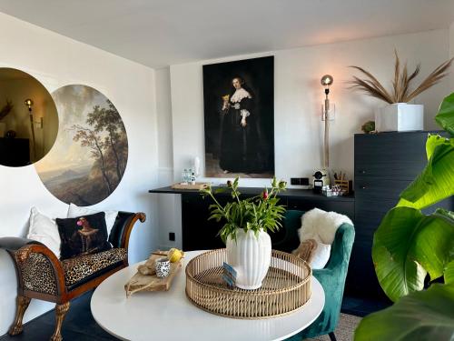 een woonkamer met een tafel en stoelen bij Rembrandts Beach Suite in Zandvoort