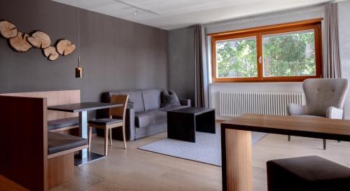 a living room with a couch and a table and chairs at Josef Mountain Resort in Avelengo