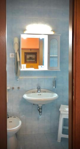 y baño con lavabo y aseo. en Hotel La Parigina, en Lignano Sabbiadoro