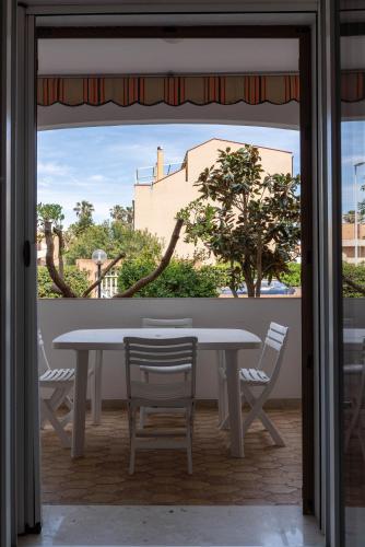 a table and chairs in a room with a window at Lido Holiday Home in Alghero