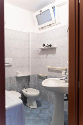 a bathroom with two sinks and a toilet at Lido Holiday Home in Alghero