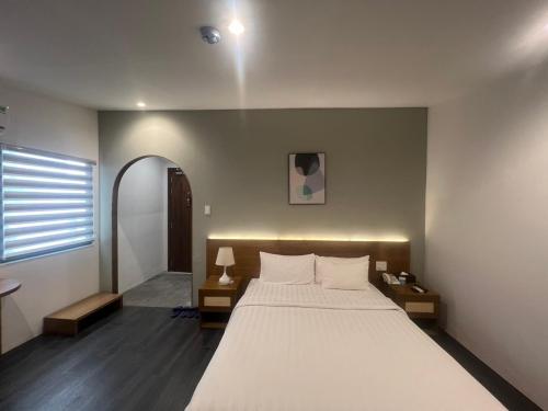 a bedroom with a large white bed and a window at A25 Hotel - 14 Hồ Huấn Nghiệp in Ho Chi Minh City