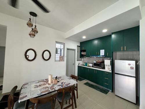 a kitchen with green cabinets and a table with chairs at Skylake Residence Luxury Family Vacation in Puchong
