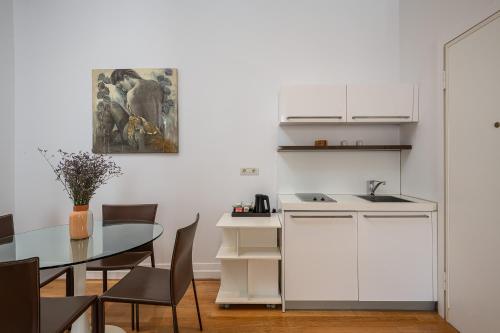 Blasius Residence في دوبروفنيك: مطبخ وغرفة طعام مع طاولة وخزانة بيضاء