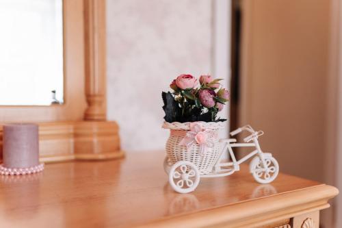 a miniature bike with flowers in a basket on a table at Двухкомнатные апартаменты на улице Естая, дом 89 напротив ТД Артур in Pavlodar