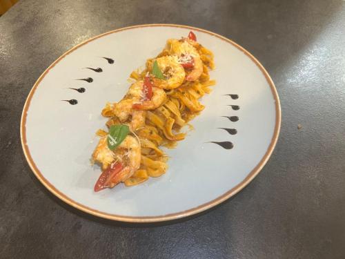 a plate of pasta with shrimp on a table at Cosy & Confort Studio près de l'aéroport in Nouaceur