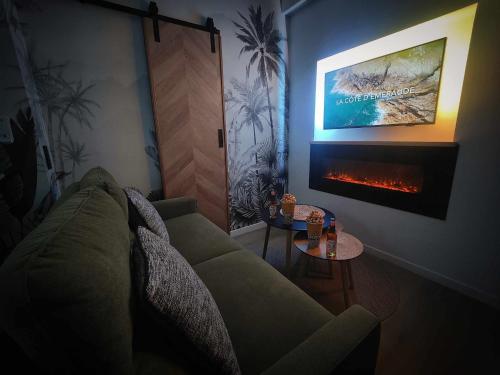 sala de estar con sofá y chimenea en La Belle Mer / MRODBNB, en Cancale