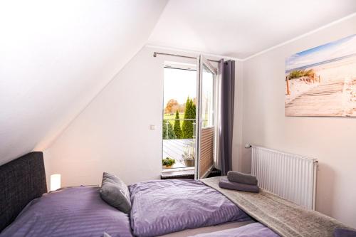 グレーミッツにあるFerienhaus Auszeit - Wohnung "Salzbrise"のベッドと窓のある寝室