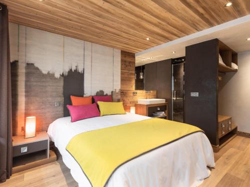 a bedroom with a large bed with colorful pillows at Appartement La Clusaz, 4 pièces, 8 personnes - FR-1-304-176 in La Clusaz