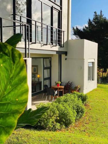 a house with a balcony and a table in the yard at Elgin Views Annex in Ouda Brug