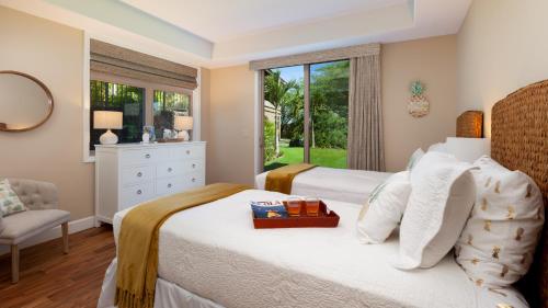 a bedroom with a bed and a window at MAUNA KEA SUNRISE Distinguished 4BR KaMilo Home with Private Beach Pass in Waikoloa