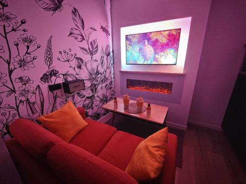 sala de estar con sofá rojo y chimenea en L'Abri Du Port / MRODBnB, en Cancale